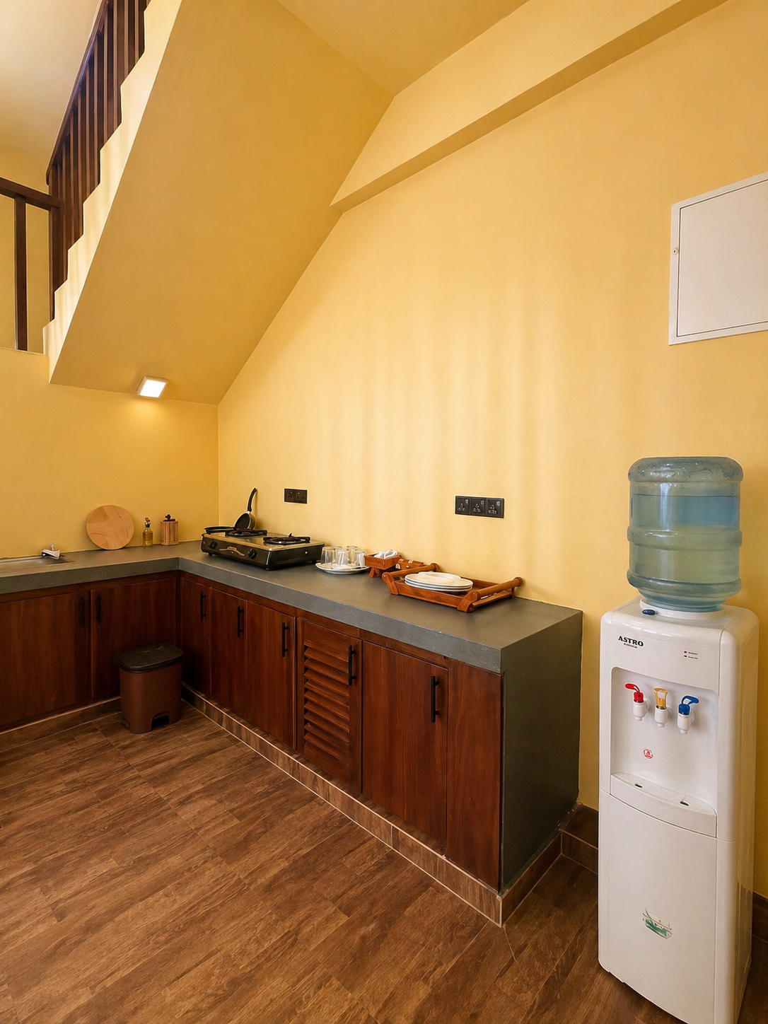 Kitchen counter with cookware, water dispenser and wooden cabinetry